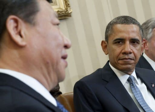 US President Barack Obama and Chinese Vice President Xi Jinping (L) speak during meetings in the Oval Office of the White House in Washington. US President Barack Obama on Tuesday urged China to play by the "same rules" in the global economy but voiced hope for cooperation