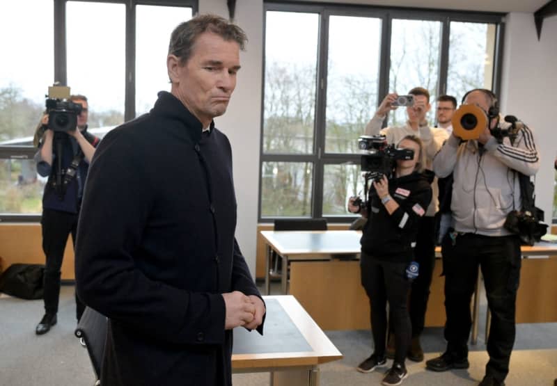 Former Germany and Arsenal goalkeeper Jens Lehmann walks past journalists at the start of his trial, accused of trespassing and property damage. Lehmann has been fined by a court in his home town of Starnberg after he attacked a neighbour's garage with a chainsaw. Peter Kneffel/dpa