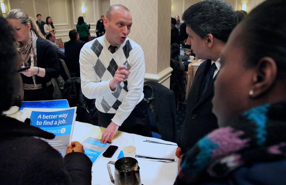 Jason Weinstein, an account manager for Workforce1 Healthcare, discusses job opportunities with attendees at JobEXPO's job fair on Wednesday, Jan. 25, 2012 in New York. The number of people seeking unemployment benefits rose last week, after falling to a nearly four-year low the previous week. (AP Photo/Bebeto Matthews)