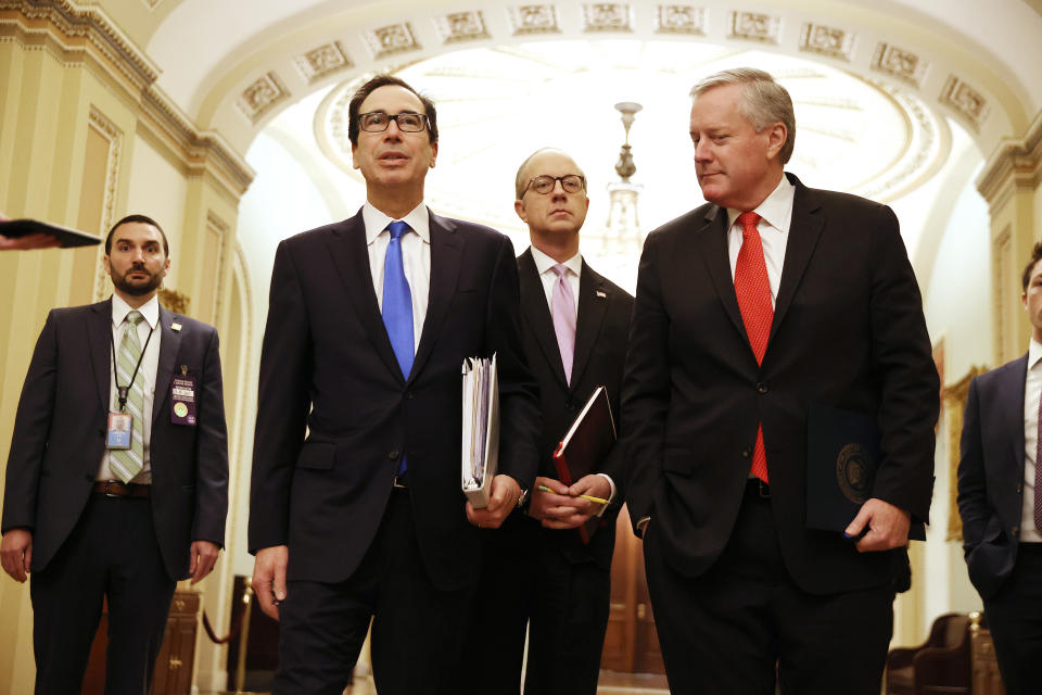 WASHINGTON, DC - MARCH 24:  Treasury Secretary Steven Mnuchin talks briefly with reporters after arriving at the U.S. Capitol with White House Director of Legislative Affairs Eric Ueland (C) and White House Chief of Staff Mark Meadows (R) to continue negotiations on a $2 trillion economic stimulus in response to the coronavirus pandemic March 24, 2020 in Washington, DC. After days of tense negotiations -- and Democrats twice blocking the nearly $2 trillion package -- the Senate and Treasury Department appear to have reached important compromises on legislation to shore up the economy during the COVID-19 pandemic. (Photo by Chip Somodevilla/Getty Images)