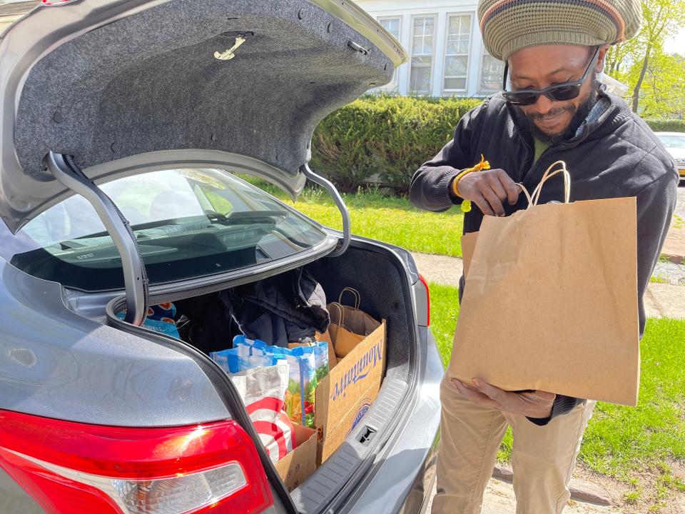 Rafael Outland checks to make sure all of the groceries are in the bag. He will then deliver the items for PLP Rochester's Free Grocery Program.