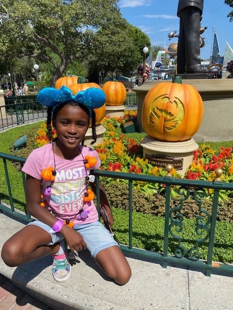 author's daughter posing in front of the pumpkin
