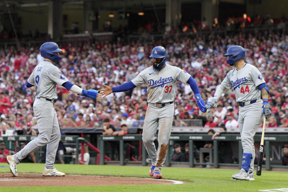 Los Angeles Dodgers' Gavin Lux, left, and Teoscar Hernández (37) celebrate with Andy Pages (44) after the first two scored on a double by Chris Taylor against the Cincinnati Reds during the second inning of a baseball game Friday, May 24, 2024, in Cincinnati. (AP Photo/Jeff Dean)