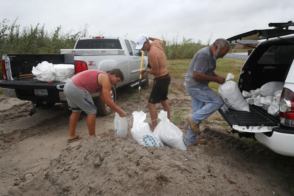 Cody Munds, Lee Martin and John Pezzi, left to right, fill sandbags in Corpus Christi.&nbsp;