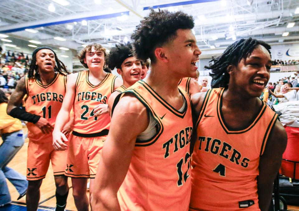 St. Xavier's Chief Cameron (4) walks off the court with his teammates after he hit the game-winning shot against rival Trinity.