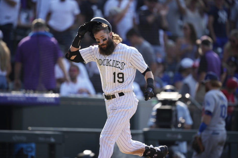 Colorado Rockies' Charlie Blackmon pulls off his helmet as he circles the bases after hitting a solo home run off Los Angeles Dodgers relief pitcher Phil Bickford during the 10th inning of a baseball game Sunday, July 18, 2021, in Denver. The Rockies won 6-5. (AP Photo/David Zalubowski)