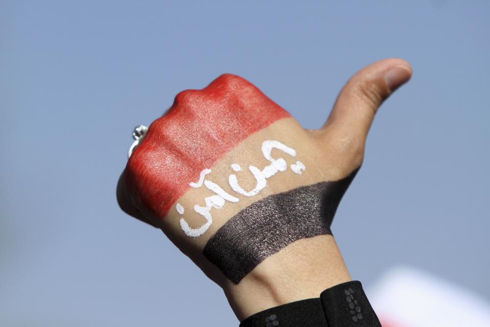 An anti-Houthi protester raises her fist painted with a Yemeni flag during a rally in Sanaa