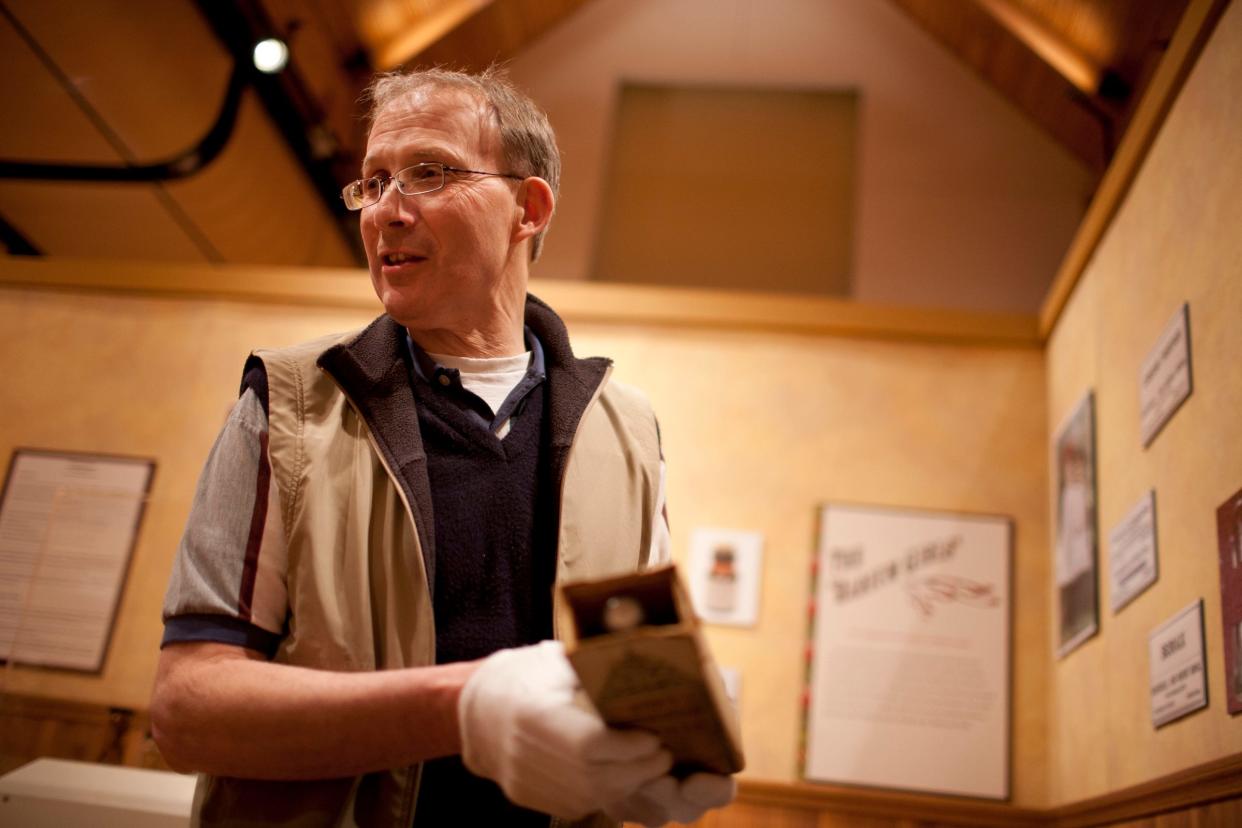 David Bainbridge, senior curator at the Center for History, examines a bottle of Ayer's Compound Extract of Sarsaparilla, a cure-all tonic in an exhibit, "Gizmos, Corsets and Concoctions," on Tuesday, Feb. 14, 2012, at the Center for History in South Bend.