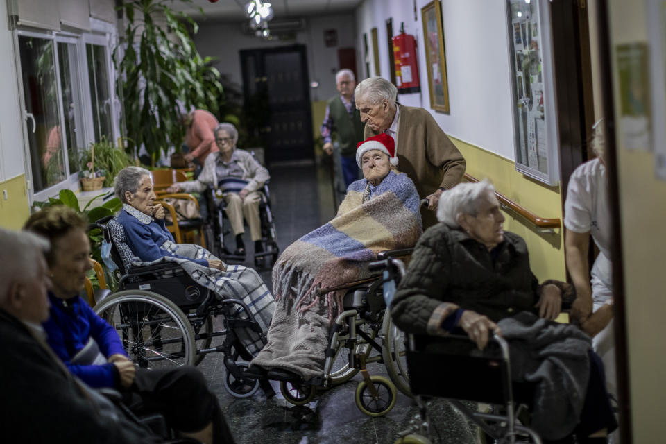 Manuel Alguacil pushes the wheelchair of her wife Carmen Riaza at an elderly care home in Pozuelo de Alarcon, outskirts of Madrid, Thursday, Dec. 24, 2020. Many of the elderly in the residence haven't celebrate Christmas eve with their relatives to prevent the spread of coronavirus (AP Photo/Bernat Armangue)