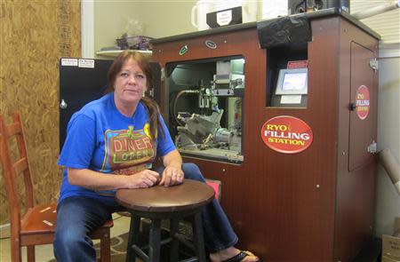 Jean Wood sits in front of a cigarette rolling machine that she is no longer allowed to operate after a federal raid on the Butt's Tobacco store that she owns with her husband Larry in a strip mall south of Seattle, July 24, 2013. REUTERS/Andy Sullivan