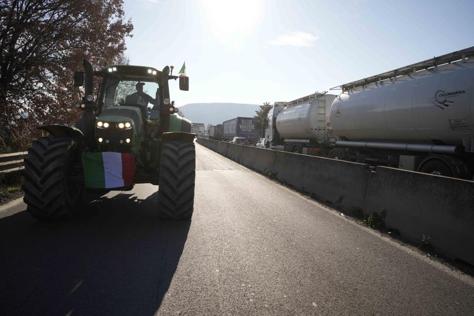 Farmers run with their ractors on the highway in Orte, Italy, Wednesday, Jan. 31, 2024. Farmers have been protesting in various parts of Italy and Europe against EU agriculture policies. (AP Photo/Andrew Medichini)