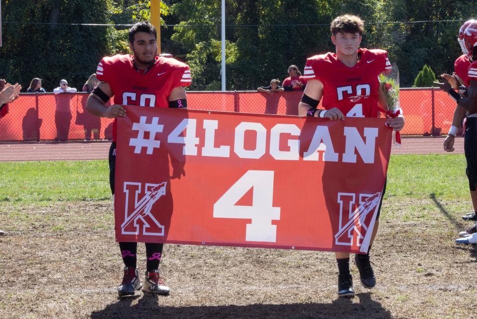 Keyport's players carry out a banner in support of Logan Blanks before the Red Raiders' 13-6 win over Keansburg Saturday.