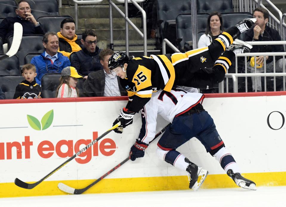 Pittsburgh Penguins right wing Josh Archibald (15) leaves his skates as he crashes into Columbus Blue Jackets defenseman Tim Bemi (75) during the second period of an NHL hockey game, Tuesday, March 7, 2023, in Pittsburgh. (AP Photo/Philip G. Pavely)