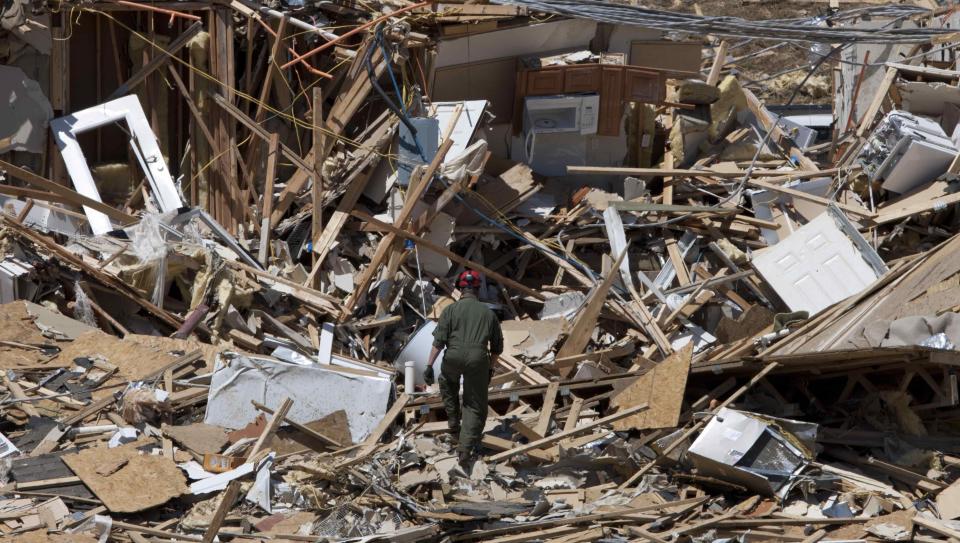 FILE - Tuscaloosa Fire Lt. Brian Phillips climbs a pile of rubble in search of survivors or bodies at an apartment building in Tuscaloosa, Ala., May 4, 2011. Meteorologists are warning of a series of severe storms that could rip across America’s Midwest and South over the next couple of weeks. One weather expert said the current persistent pattern of storm ingredients is consistent with the April 2011 tornado onslaught, one of the largest, deadliest and most destructive tornado outbreaks in American history. (AP Photo/Dave Martin, File)