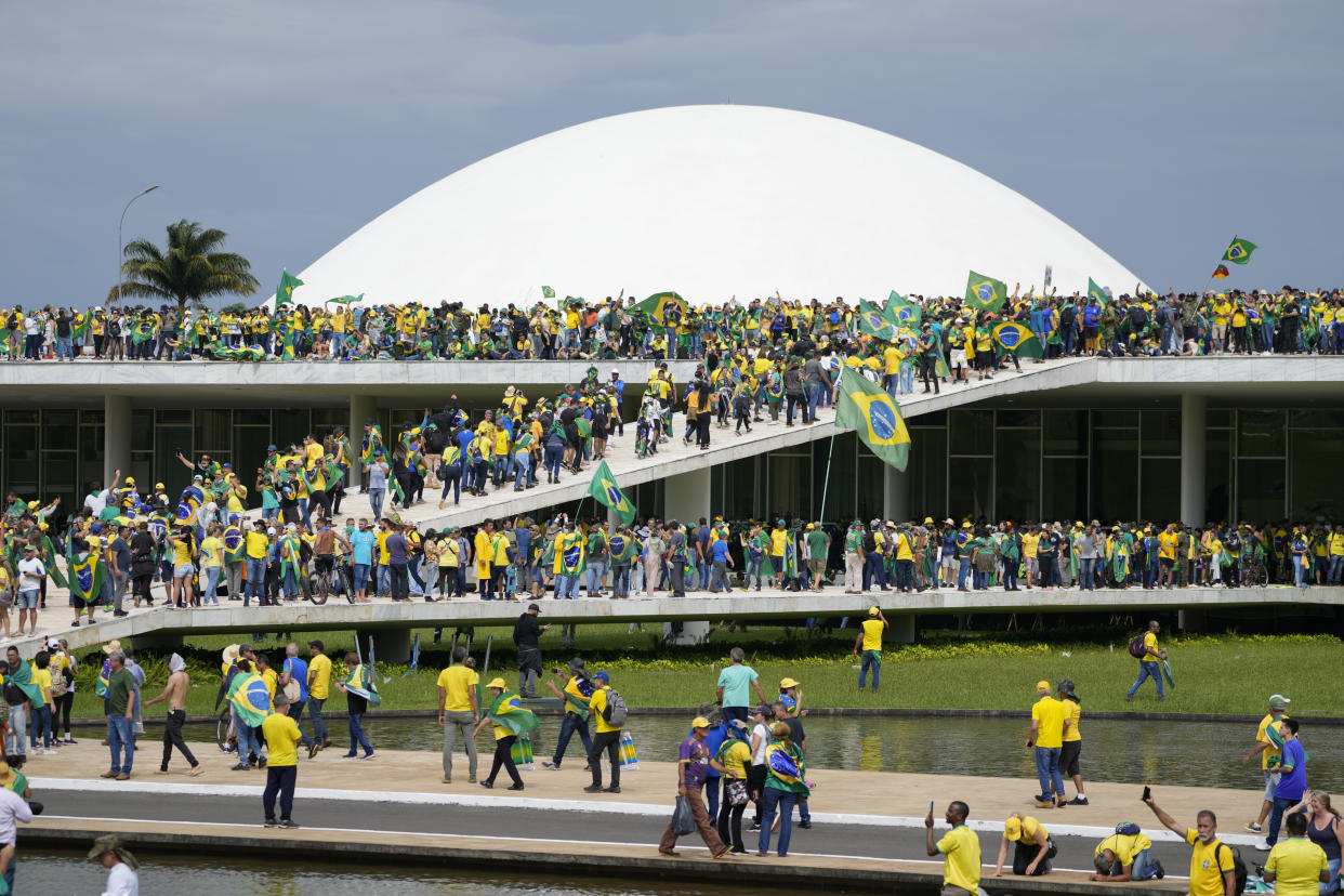 Protesters, mostly dressed in yellow and turquoise T-shirts, swarm up a ramp at the National Congress.