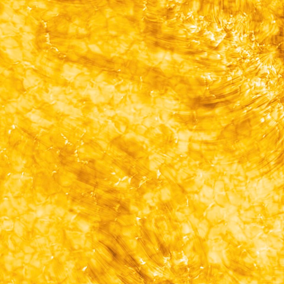 bright yellow solar surface with whispy layer of atmosphere above plasma cells underneath