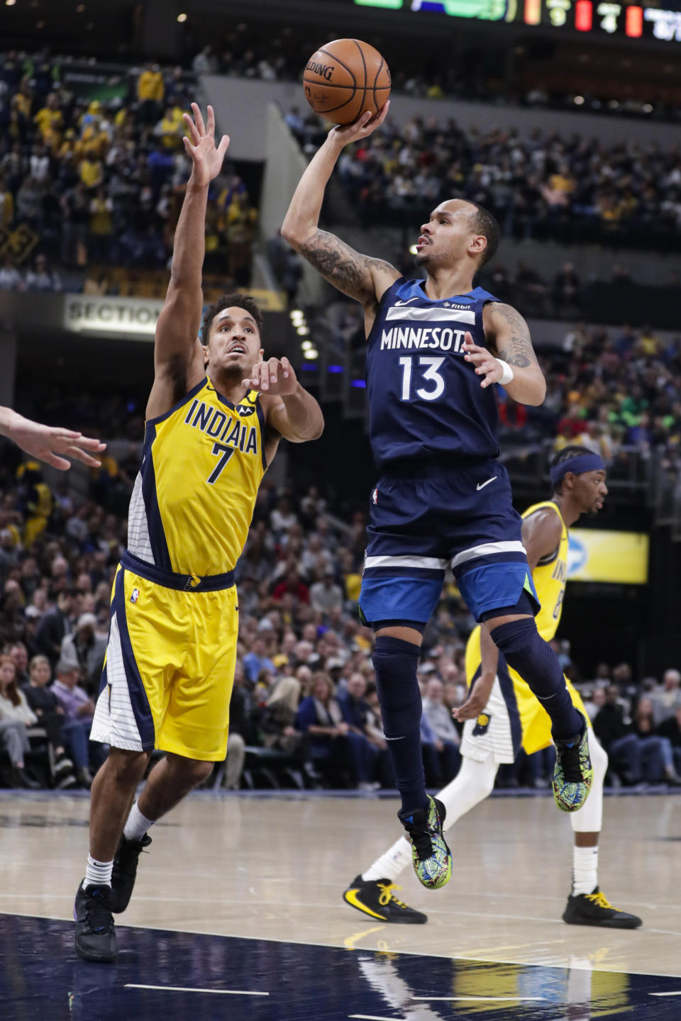 Minnesota Timberwolves guard Shabazz Napier (13) shoots next to Indiana Pacers guard Malcolm Brogdon (7) during the first half of an NBA basketball game in Indianapolis, Friday, Jan. 17, 2020. (AP Photo/Michael Conroy)