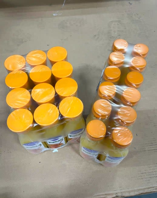 Two packages of Tropicana orange juice bottles, sealed in plastic wrap, placed on a surface