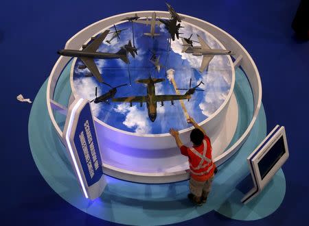 A worker cleans model aircrafts on display at the Singapore Technology (ST) Engineering booth during a preview tour of the Singapore Airshow at Changi exhibition center in Singapore February 14, 2016. REUTERS/Edgar Su