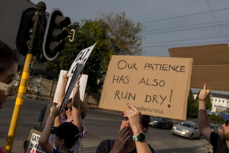 A protester in Johannesburg, South Africa holds a sign that reads: "our patience has also run dry!"