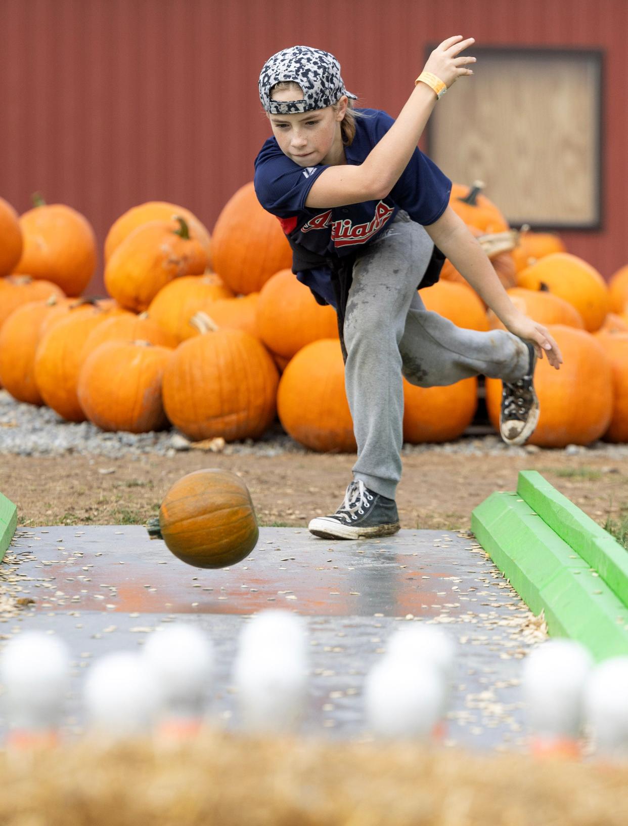 Kole Bohland, 13, of Plain Township tries his hand at pumpkin bowling at Nickajack Farms in Lawrence Township.