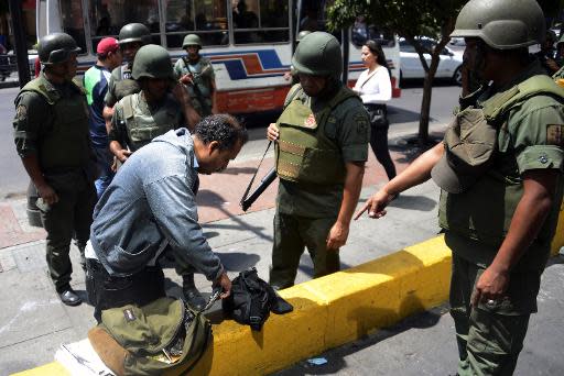 Agentes de la Guardia Nacional Bolivariana revisan a un hombre el 17 de marzo de 2014 en la plaza Altamira de Caracas (AFP | Leo Ram�rez)