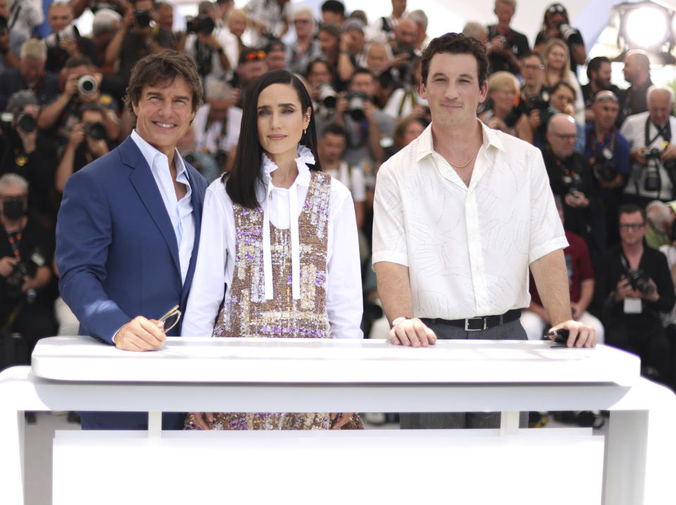 Tom Cruise, Jennifer Connelly y Miles Teller, de izquierda a derecha, posan para la prensa con motivo del estreno de "Top Gun: Maverick" en la 75ta edición del Festival Internacional de Cine de Cannes, el miércoles 18 de mayo de 2022 en Cannes, Francia. (Foto por Vianney Le Caer/Invision/AP)