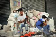 Syrian rebels attack the municipal building in the city center of Selehattin, near Aleppo. Syria admitted Monday it has chemical weapons and warned of using them if attacked, though not against its own civilians, as regime troops reclaimed most of Damascus after a week of heavy clashes