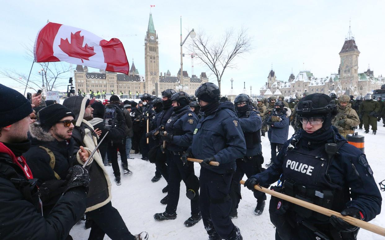 Protesters from the "Freedom Convoy" in Ottawa are moved from Wellington Street in front of Parliament Hill by police officers after blockading the the downtown core of Canada's capitol for over three weeks. in Ottawa.