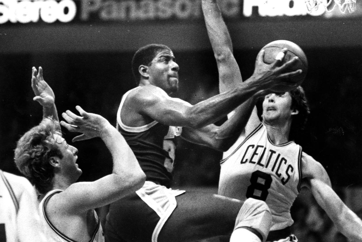 BOSTON, MA - MAY 27: Los Angeles Lakers' Magic Johnson splits the defense of Celtics' Larry Bird, left, and Scott Wedman to score two points in Game One of the 1985 NBA Finals between the Boston Celtics and the Los Angeles Lakers at the Boston Garden on May 27, 1985.  (Photo by George Rizer/The Boston Globe via Getty Images)