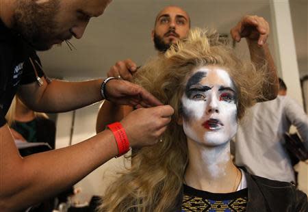 A model has her hair styled backstage before the Vivienne Westwood Red Label Spring/Summer 2014 collection presentation during London Fashion Week September 15, 2013. REUTERS/Suzanne Plunkett