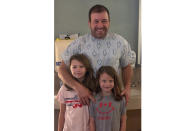 This undated photo provided by Roush Racing shows NASCAR driver Ryan Newman and his daughters, Brooklyn Sage, left, and Ashlyn Olivia, at Halifax Medical Center in Daytona Beach, Fla. Newman is fully alert, walking around the hospital and joking with staff two days after his frightening accident on the final lap of the Daytona 500 auto race. Roush Fenway Racing said Wednesday, Feb. 19, 2020, the 42-year-old “continues to show great improvement.” (Roush Racing via AP)