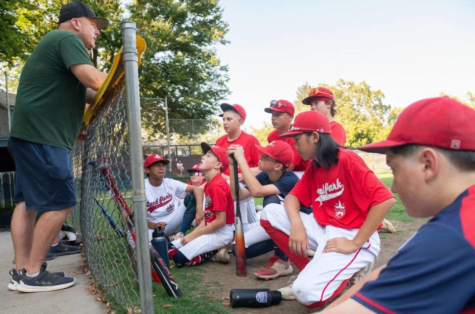 Land Park Pacific All Stars manager Jeff Zimmerman, left, speaks to players on Monday, July 29, 2024, at Dooley Field in Sacramento. “Whether it’s winning or losing, failures or successes, I hope that they’ve learned something that will help them in their future lives,” Zimmerman said.