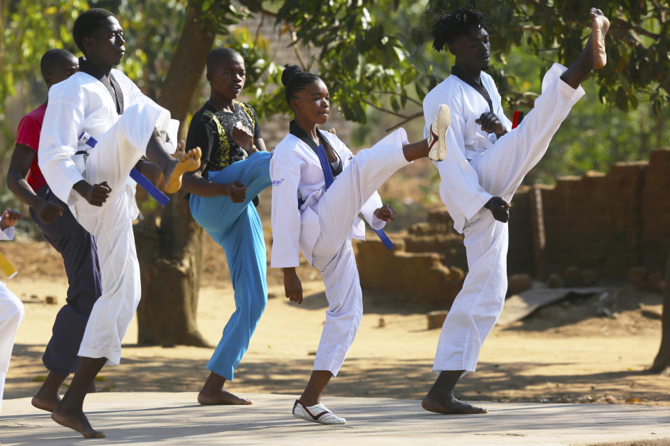 Natsiraishe Maritsa, second right, goes through taekwondo kicking drills during a practice session in the Epworth settlement about 15 km southeast of the capital Harare, Saturday Nov. 7, 2020. In Zimbabwe, where girls as young as 10 are forced to marry due to poverty or traditional and religious practices, a teenage martial arts fan 17-year old Natsiraishe Maritsa is using the sport to give girls in an impoverished community a fighting chance at life. (AP Photo/Tsvangirayi Mukwazhi)