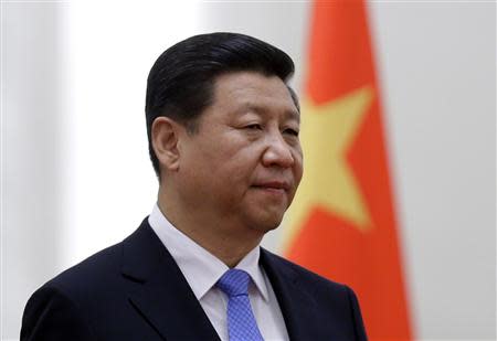 China's President Xi Jinping stands next to a Chinese national flag during a welcoming ceremony at the Great Hall of the People, in Beijing, in this November 13, 2013 file photo. REUTERS/Jason Lee/Files