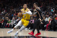 Los Angeles Lakers guard Russell Westbrook drives against Atlanta Hawks guard Aaron Holiday during the first half of an NBA basketball game Friday, Dec. 30, 2022, in Atlanta. (AP Photo/Hakim Wright Sr.)