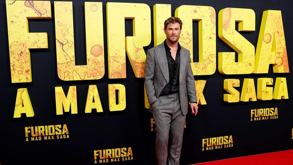 Chris Hemsworth in a grey suit and black shirt on the carpet for his movie "Furiosa"