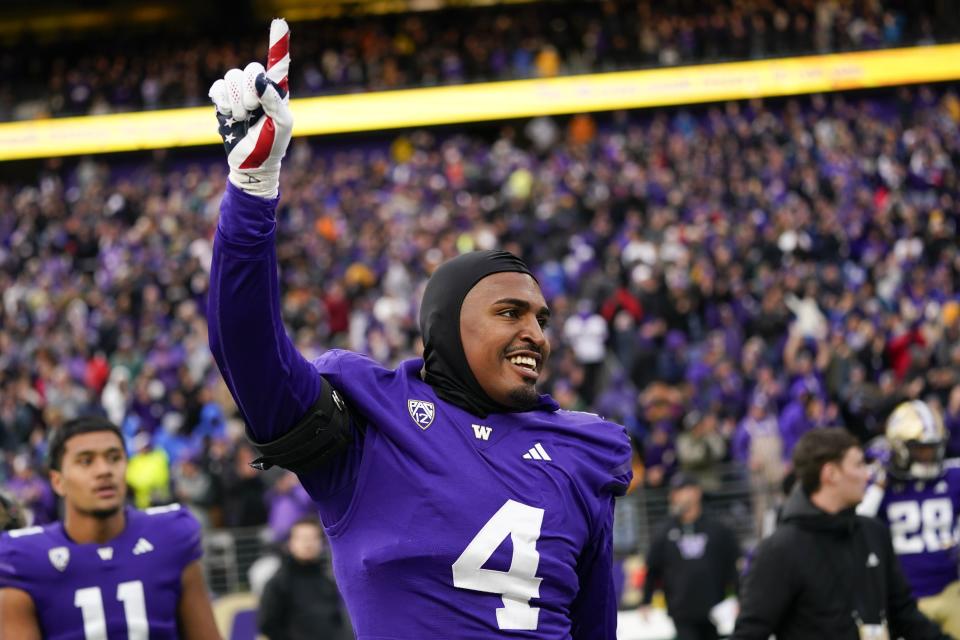 Washington defensive end Zion Tupuola-Fetui points as he walks onto the field to celebrate a 35-28 win over Utah in an NCAA college football game Saturday, Nov. 11, 2023, in Seattle. | Lindsey Wasson, Associated Press