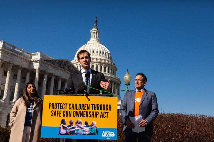 Rep. Jake Auchincloss at the microphone with a placard saying: Protect Children Through Safe Gun Ownership Act. 