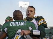 Saskatchewan Roughriders quarterback Darian Durant hugs Edmonton Eskimos quarterback Mike Reilly (R) at the end of their CFL football game in Regina, Saskatchewan October 12, 2013. The Saskatchewan Roughriders defeated the Edmonton Eskimos 14-9. REUTERS/Matt Smith (CANADA - Tags: SPORT FOOTBALL)