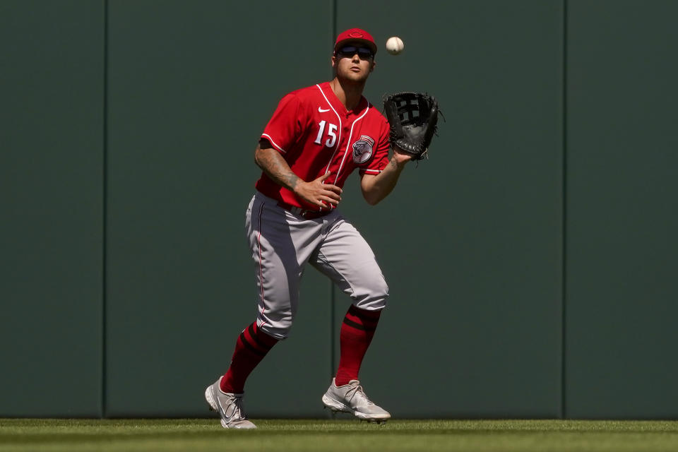 Cincinnati Reds' Nick Senzel (15) fields a fly-out hit by Los Angeles Angels' Kurt Suzuki during the second inning of a spring training baseball game, Friday, April 1, 2022, in Tempe, Ariz. (AP Photo/Matt York)