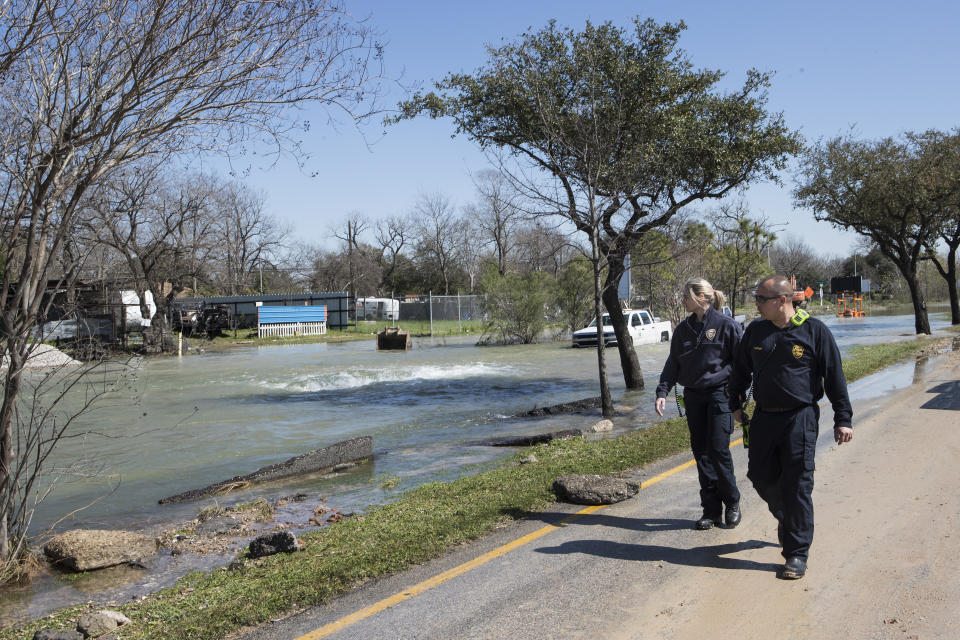 A pair of firefighters walk past a water main break that flooded Clinton Drive and a portion of the East Loop 610 on Thursday, Feb. 27, 2020 in Houston. The flooding closed the major freeway that circles the city. ( Brett Coomer/Houston Chronicle via AP)