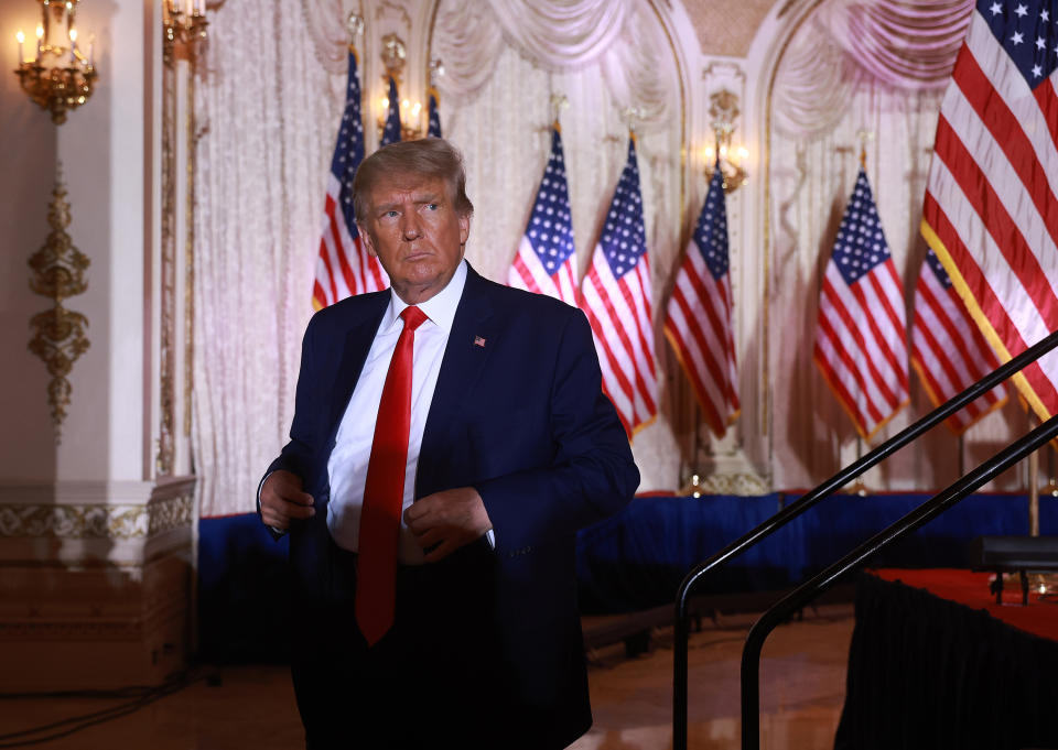 Looking disgruntled, former U.S. President Donald Trump leaves the stage, with a bank of U.S. flags in the background.