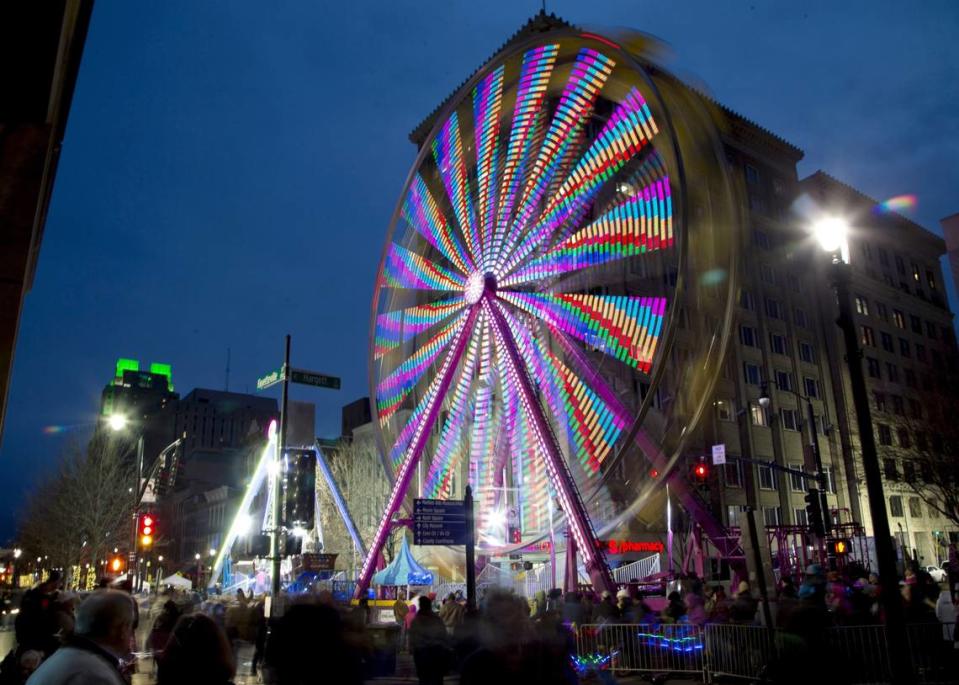 A brightly lit, colorful Ferris wheel spins around on Fayetteville Street during First Night Raleigh in 2016. The event features arts, concerts, rides and more.