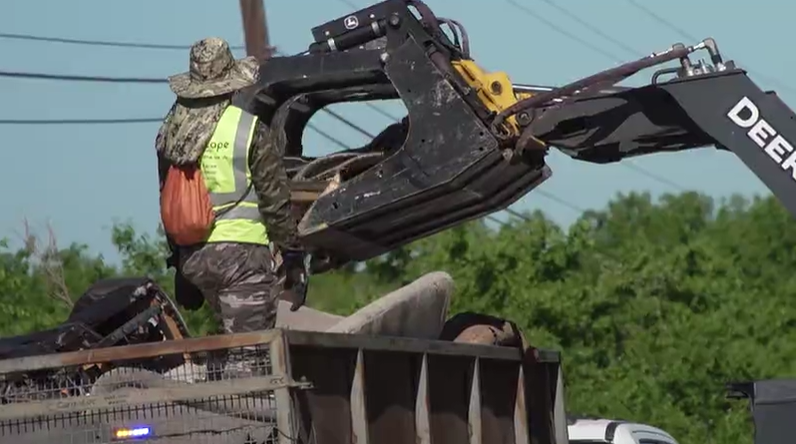 Heavy equipment picks up everything from furniture to construction materials along Lindell Lane in East Austin (KXAN Photo/Richie Bowes)