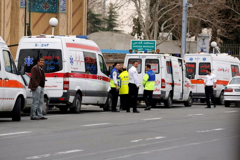 Iranian emergency services gather near Tehran's Mehrabad airport as relatives of passengers on a plane that crashed gather on February 18, 2018