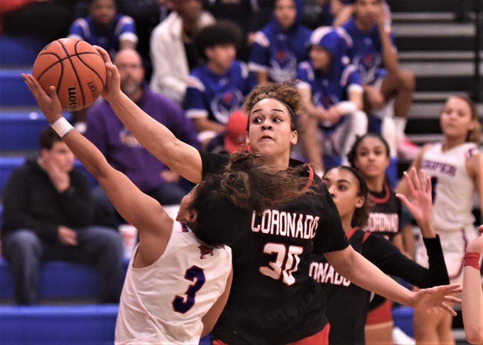 Lubbock Coronado's Kya Smith, right, blocks a shot by Cooper's Alliyah Ralston in the first half.