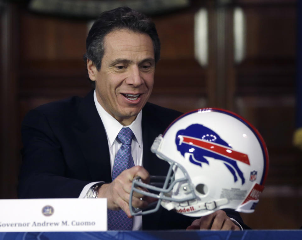 New York Gov. Andrew Cuomo holds a Buffalo Bills football helmet that was presented to him by Lt. Gov. Robert Duffy in the Red Room at the Capitol on Wednesday, Jan. 2, 2013, in Albany, N.Y. Cuomo was unable to attend a news conference in December announcing a 10-year lease extension between the state, Erie County and the Bills. (AP Photo/Mike Groll)