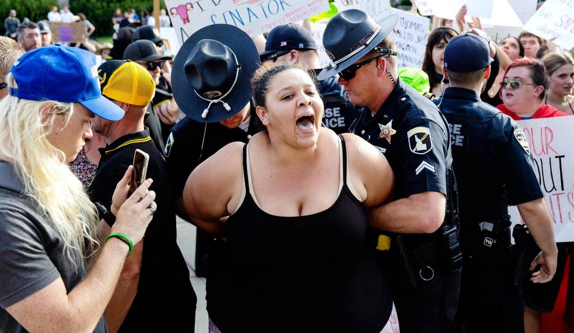 Idaho State Troopers detain a woman during a celebration of the overturn of Roe vs. Wade held at the Idaho Statehouse in Boise on Tuesday, June 28, 2022. The anti-abortion event was met by a crowd of protestors defending the right to abortion.