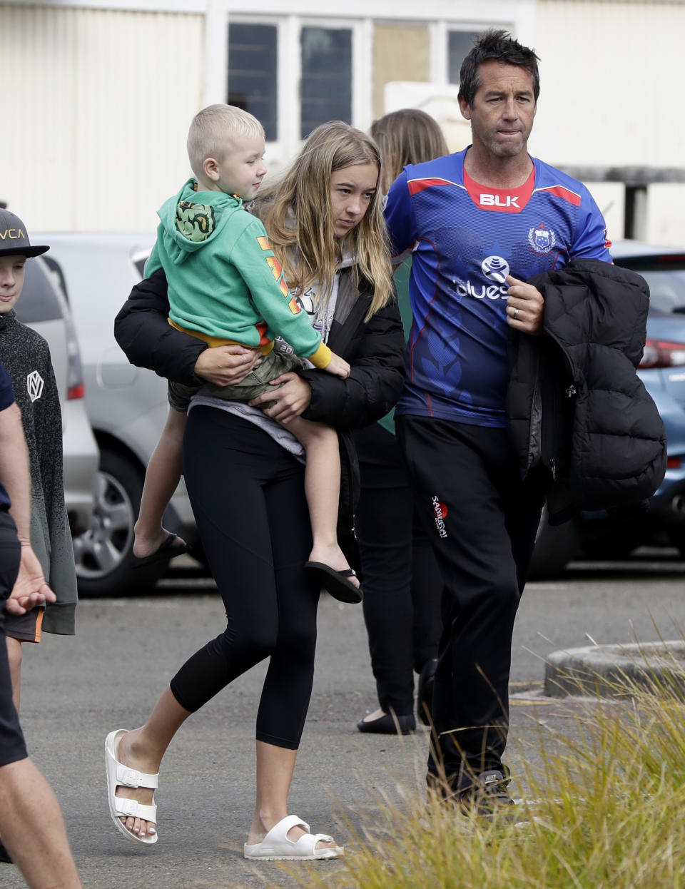 Mark Inman, right, brother of volcano victim Hayden Marshall-Inman, walks with family members after arriving back to the Whakatane wharf following a blessing at sea ahead of the recovery operation off the coast of Whakatane New Zealand, Friday, Dec. 13, 2019. A team of eight New Zealand military specialists landed on White Island early Friday to retrieve the bodies of victims after the Dec. 9 eruption. (AP Photo/Mark Baker)